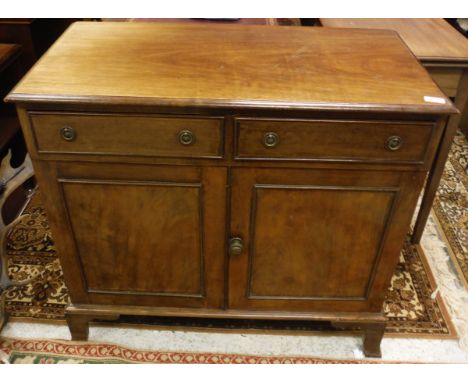 A circa 1900 mahogany side cabinet with two drawers over a single cupboard door on bracket feet