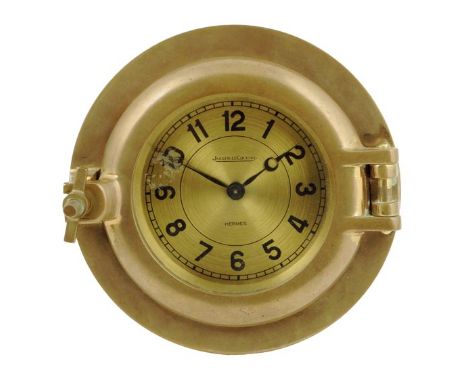 Jaeger LeCoultre retailed by Hermes. A brass timepiece of porthole form, the 4 inch gilt dial signed Jaeger LeCoultre, Hermes