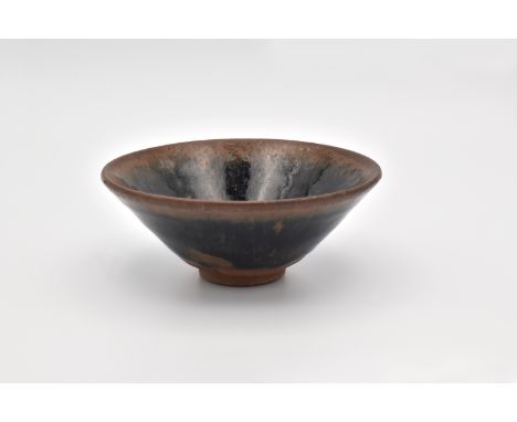 The conical bowl covered inside and out in a russet and olive-black glaze falling short of the foot, exposing the unglazed pu