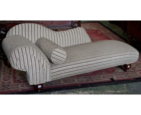 A Victorian chaise, shaped back, scrolling arm, turned legs, ceramic casters.
