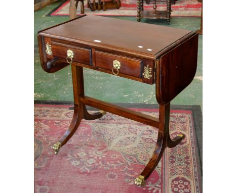 A Regency reproduction sofa table, two drawers to frieze, lion mask escutcheons, loop handles, sabre legs, paw terminals, bra