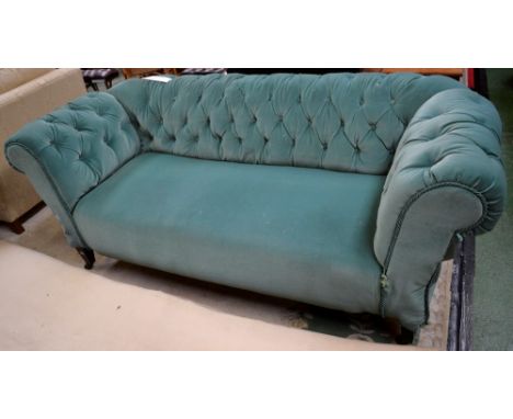 An Edwardian double drop arm sofa, button upholstered, tapering forelegs, ceramic casters.