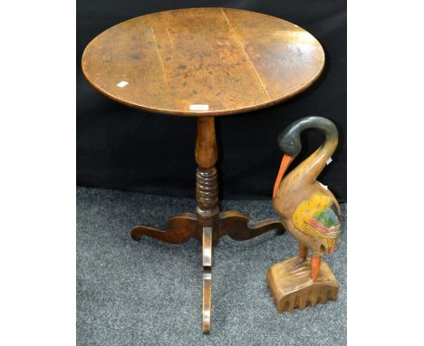 An oak tripod table, circular top, turned column, hipped cabriole legs; a wooden carving of a stylized heron (2)