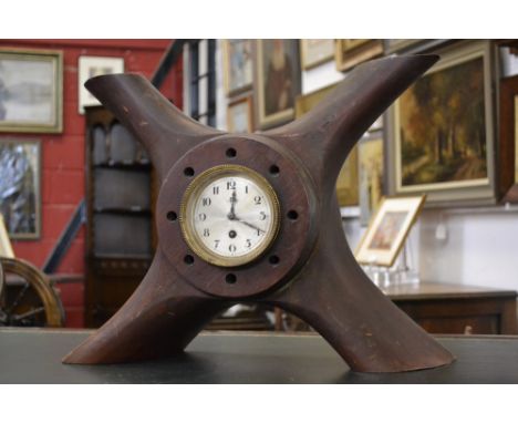 An eight day clock mounted in a World War I four bladed wooden propeller boss stamped T6296 1917 G217 N12. 12 CYL RAF4A 140HP