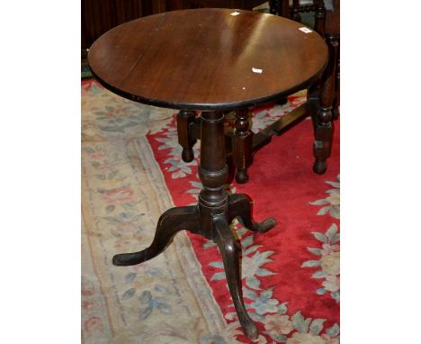 A George III mahogany tilt-top table, circular top, canon barrel column, tripod base. C1800