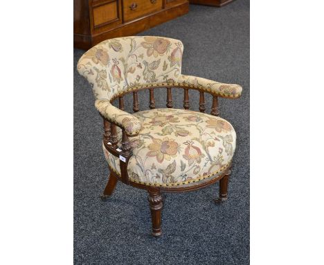 A Victorian tub chair, padded scroll back padded horseshoe arm rail, turned, fluted and carved spindles, stuffed overseat, ta