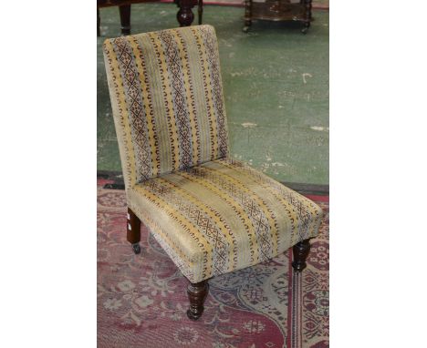 A Victorian nursing chair, padded back and seat, turned forelegs, ceramic casters, circa 1880.
