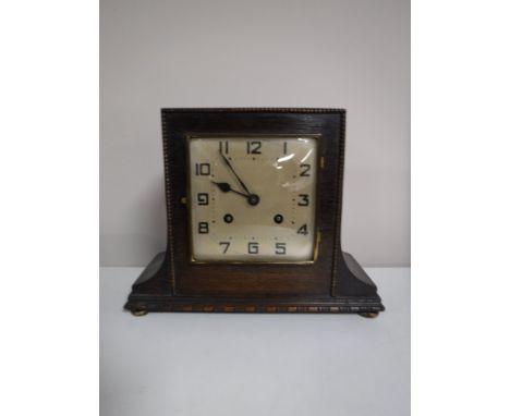 An early twentieth century oak mantel clock with pendulum and key