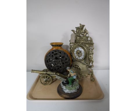 A tray containing a brass French style mantel clock, together with a brass cannon, a Northumbrian Artists figurine of a fishe