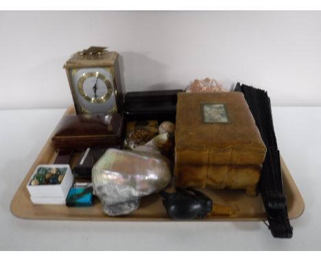 A tray containing leather jewellery box, hand fan, shells, lighters, marble mantel clock, a Mauchline backed notebook 