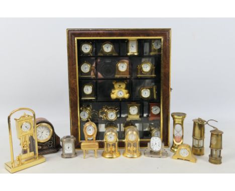 A small display case containing a quantity of miniature clock, a further quantity of loose examples and similar. [2]