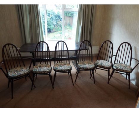 An Ercol refectory style dining table measuring approximately 72 cm x 182 cm x 81 cm with six Quaker dining chairs (4 + 2).

