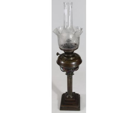 A late 19thC metal oil lamp, of classical form, the circular burner on an Ionic column and stepped square base, 59cm high.
