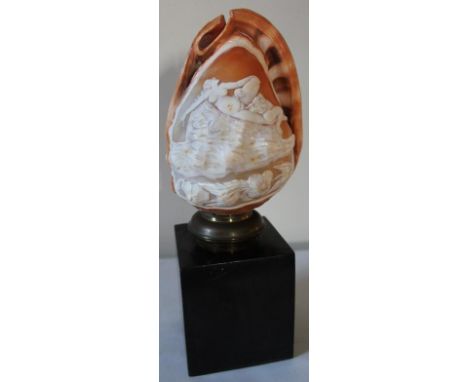 A 19thC Italian conch cameo shell lamp, deeply carved with male and female in an erotic pose