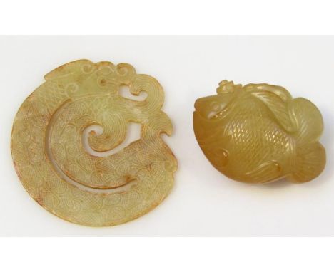 A heavily carved green jade fish, of shaped outline, probably Chinese, unmarked, 5cm wide, and a carved dragon pendant. (2)