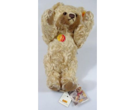 A late 20thC Steiff blond plush Teddy bear, with velvet pads and articulated limbs, 30cm high, with label to the ear and fron