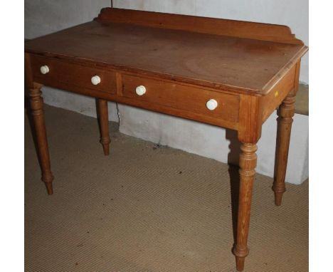 A Victorian stripped pine dressing table, with ceramic handles and turned legs, 107cm wide