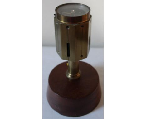 A tabletop compass, in brass on a mahogany plinth, 20cm high