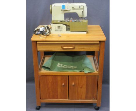 BERNINA ELECTRIC SEWING MACHINE on a wheeled modern pine trolley worktable with twin door cupboard base, 85cms H, 73cms W, 55