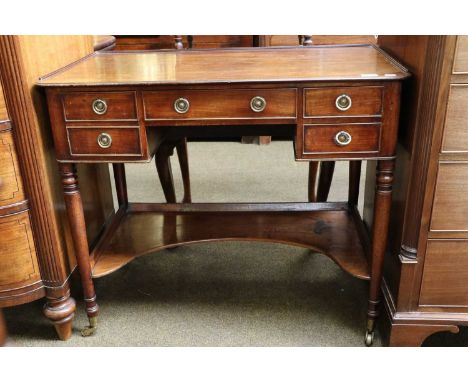 A George III Mahogany Dressing Table, with four drawers, shaped undertier and slender turned supports capped with brass casto