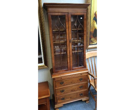 A Reproduction Walnut Bookcase, the glazed Upper section over a dressing slide above three drawers, 70cm by 32cm by 82cm
