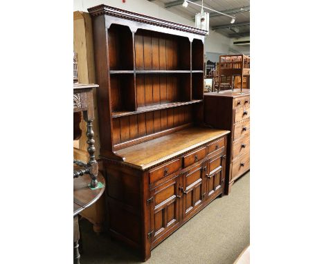 A Reproduction Oak Dresser and Rack, with panelled rack over a base of three drawers and three cupboards, makers Siesta, Newc