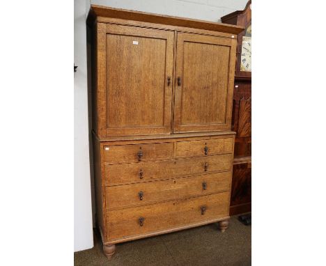 A George III Oak Press Cupboard, raised on a chest of two short over three long graduated drawers, over later turned feet, 12