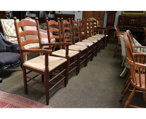 A Set of Eight Oak Ladder Back Kitchen Chairs, 20th century, with rush seats and including two carvers (8)