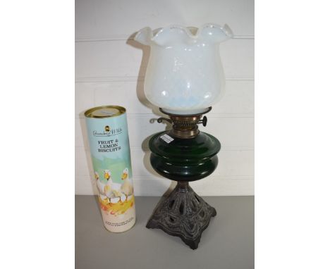 LATE 19TH CENTURY OIL LAMP WITH FRILLED GLASS SHADE, GREEN GLASS FONT AND A CAST METAL BASE