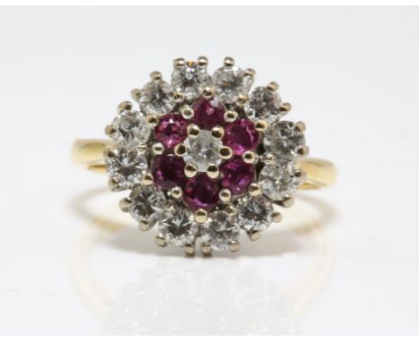 Ruby and diamond cluster ring, central round brilliant cut diamond weighing an estimated 0.10 carat, with a surround of round