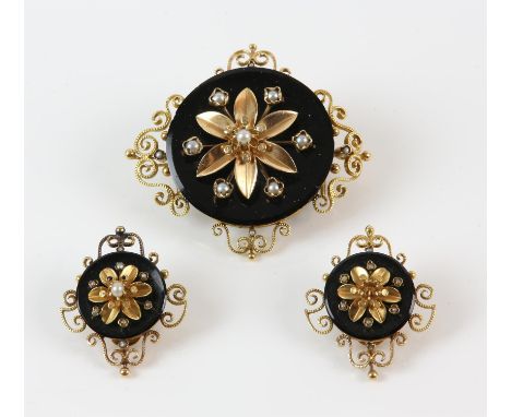 An onyx and pearl brooch, circular motif with a gold flower set to the centre, with gold openwork to the surround, in tested 