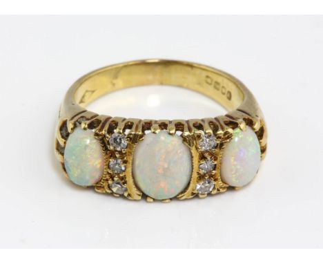 Opal and diamond carved half hoop ring, set with three cabochon cut opals, separated by single cut diamonds, in 18 ct yellow 