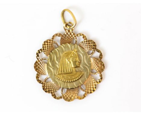 A double sided medallion pendant, with a figure to the centre and an openwork border with engine turned detail, tested as 18 