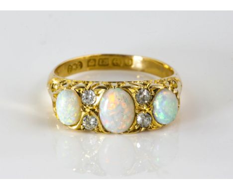 Opal and diamond carved half hoop ring, set with three oval cabochon cut opals, separated by old cut diamonds, in 18 ct yello