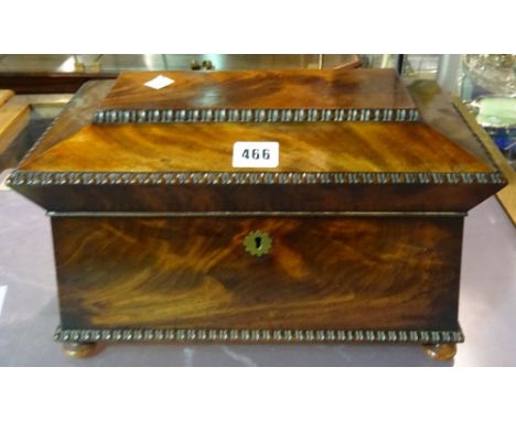 A George IV mahogany tea caddy of sarcophagus form, on bun feet, 34cm wide x 20cm high.