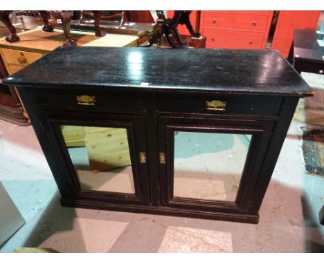 An early 20th century ebonised side cabinet with two drawers above two mirrored cupboard doors, 133cm wide x 92cm high. 