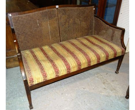 A George III style mahogany framed bergere two seat sofa on square tapering supports, 117cm wide. 