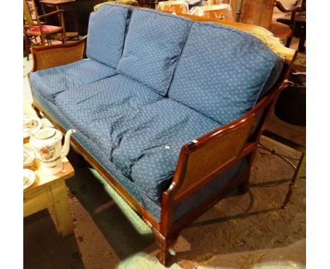 A 20th century mahogany framed bergere suite comprising a sofa and two low armchairs on ball and claw feet, (3). 