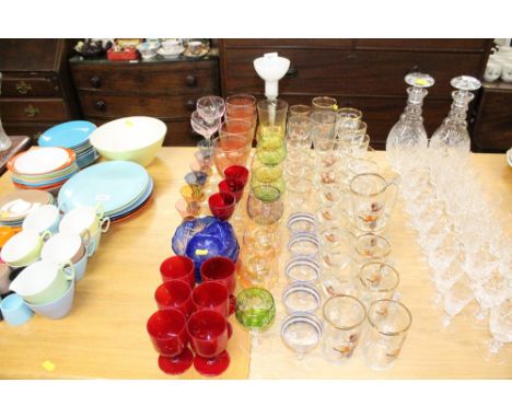 A quantity of various coloured glassware to include an air twist stem candlestick