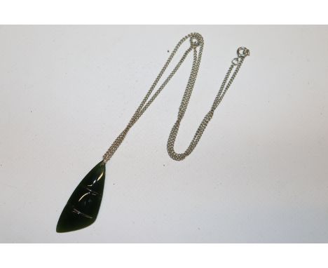 A jade coloured pendant hung to fine link chain 