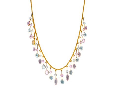An Edwardian gold graduated fringe necklace, circa 1905, alternately-set with vari-shape pink topaz and aquamarine on knife-e