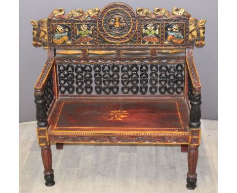 A continental carved wood bench with figural and horse head decoration, W108 x D50 x H100cm