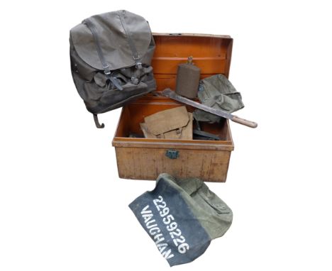 A Vintage metal travelling trunk containing military items of various ages, to include bergens, flasks, pouches, and a machet