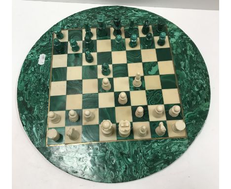 A malachite and marble circular chess board and chess pieces to match, the board 37.2 cm diameter, king 5 cm high