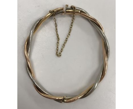 An unmarked yellow and white metal childs intertwined bangle 6 cm x 5 cm, 20 g