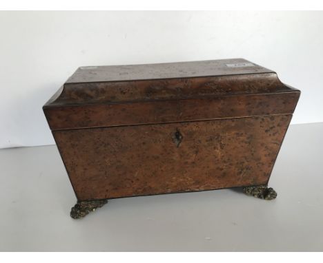 A 19th Century burr yew tea caddy of sarcophagus form, the hinged lid opening to reveal a fitted interior with cut glass bowl