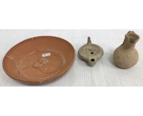 A Roman style pottery oil lamp with serpent decoration to top and impressed mark to base 10 cm long together with a similar m