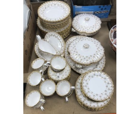 A Spode fleur de lys gold dinner service comprising twelve dinner plates, eleven soup bowls, twelve dessert plates, twelve si