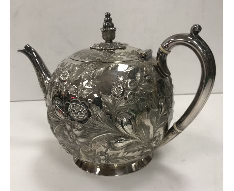 A Victorian silver bullet-shaped tea pot with all over floral and foliate embossed decoration (by Jonathan Round, Sheffield 1