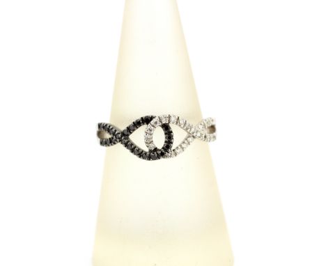 An 18ct white gold ring set with brilliant cut diamond and fancy black diamonds, N.5.